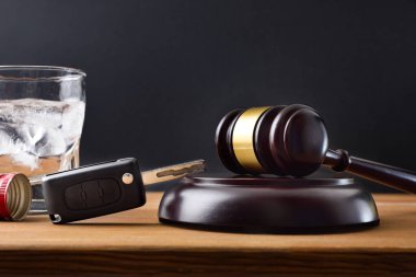 Gavel, arabanın anahtarı ve içinde alkol olan ahşap masa ve siyah izole arka plan. Alkol oranlı araç kullanmaktan dava açılmasına izin verilmiyor