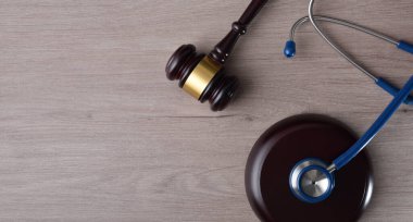 Adaletin sağlıkta ve sağlıkta adil adalet kavramını kavrayın. Tokmak ve steteskop ahşap masada olsun. Üst görünüm.