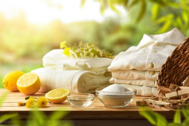 Kıyafetleri doğal ürünlerle sürdürülebilir bir şekilde yıka limon, kabartma tozu ve sirke gibi doğada giysi havluları olan ahşap masa üzerinde. Ön manzara. Yatay bileşim.