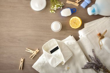 Elbiseler arka planı havlularla ve ahşap masadaki ürünlerle yıkıyor. Üst Manzara. Yatay bileşim.