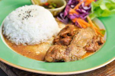 Domuz yahnisi, pilav ve soslu domuz eti ya da yahni ve sebzeli pilav.