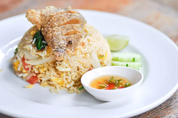 stir fried rice or fried rice with fried fish topping and sauce