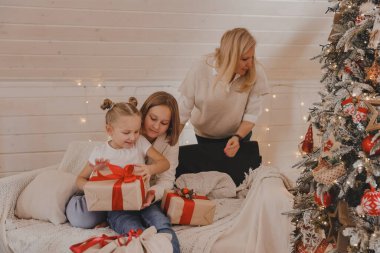 Çocuklar ve anne Noel ağacını süslüyor, Mutlu Noeller ve yeni yıl tatilleri. Aile, kış tatili ve insan konsepti, portre seven aile, yakın çekim..