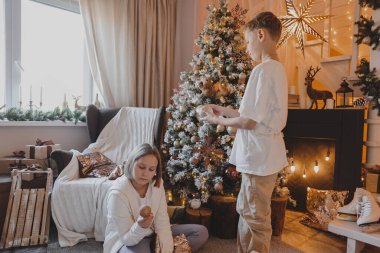 Mutlu aile, Noel ağacını bıldırcın ve hediyelerle süslüyor oturma odasında, Mutlu Noeller ve yeni yıl tatilleri. Aile, kış tatili ve insanlar konsepti.