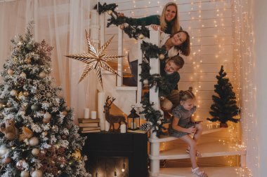 Morher ve Çocuklar yılbaşı atmosferinde. Aile Noel ve hediyelerle mutlu. Çocuklar yılbaşı ağacında hediyelerle.