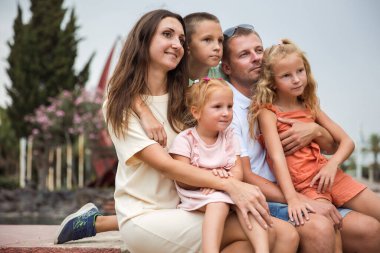 Family spending time together, cheerful parent with kids walking in the park in good weather