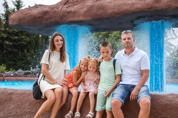 Family spending time together, cheerful parent with kids walking in the park in good weather