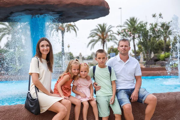 Family spending time together, cheerful parent with kids walking in the park in good weather