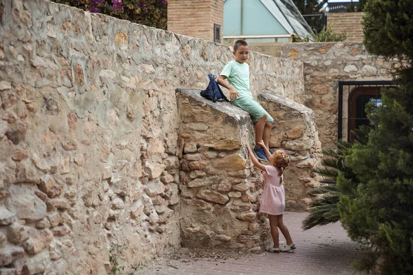 Family spending time together, cheerful parent with kids walking in the park in good weather