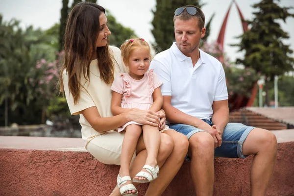 Family spending time together, cheerful parent with kids walking in the park in good weather