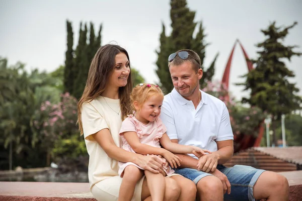 Family spending time together, cheerful parent with kids walking in the park in good weather