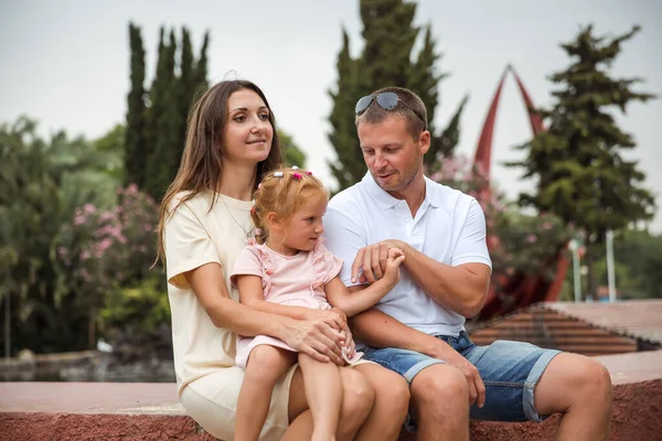 Family spending time together, cheerful parent with kids walking in the park in good weather