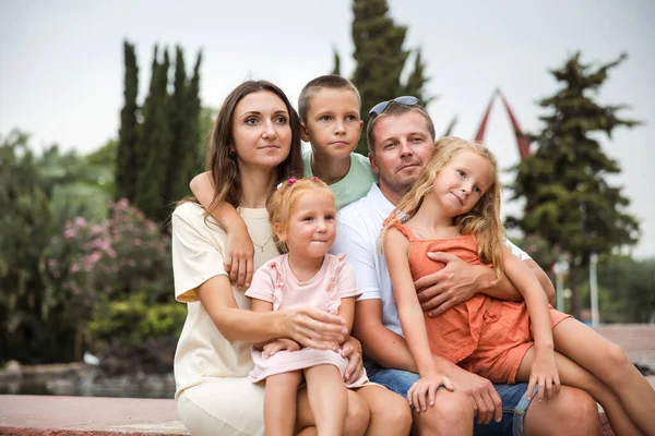Family spending time together, cheerful parent with kids walking in the park in good weather