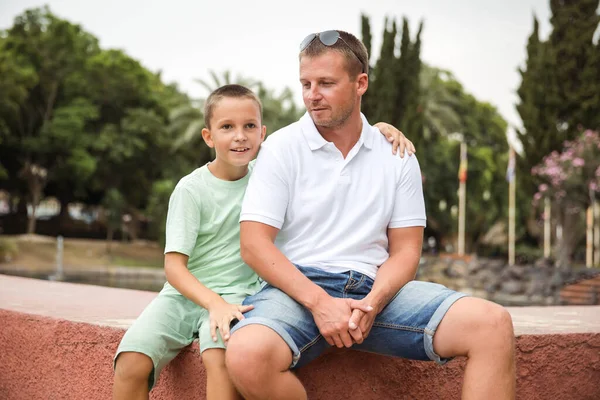 Father and son walking in the city park, family vacation, healthy lifestyle