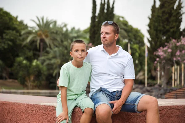 Father and son walking in the city park, family vacation, healthy lifestyle