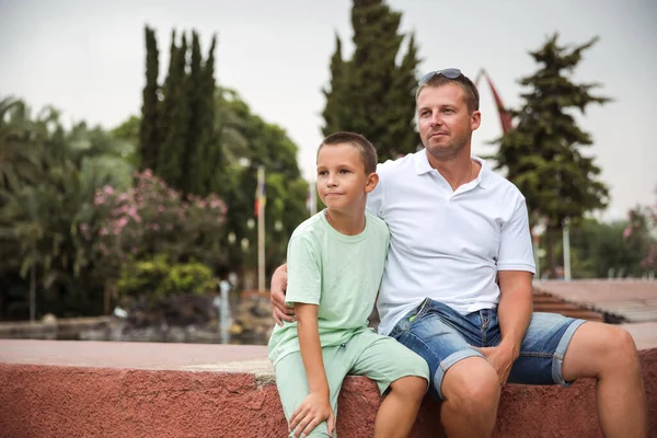 Father and son walking in the city park, family vacation, healthy lifestyle