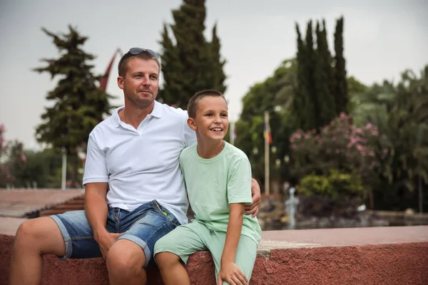 Father and son walking in the city park, family vacation, healthy lifestyle