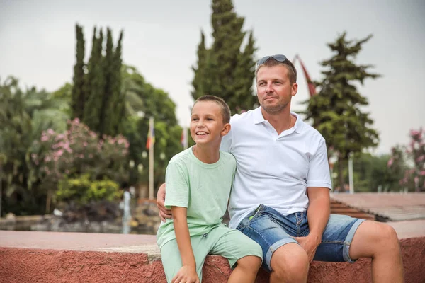 Father and son walking in the city park, family vacation, healthy lifestyle