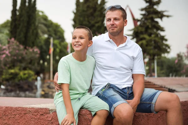 Father and son walking in the city park, family vacation, healthy lifestyle