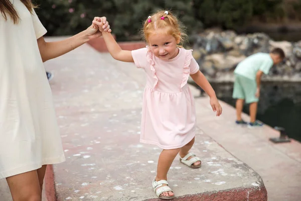 A mother with children walks in a city park, family vacation, the concept of a healthy lifestyle and family leisure