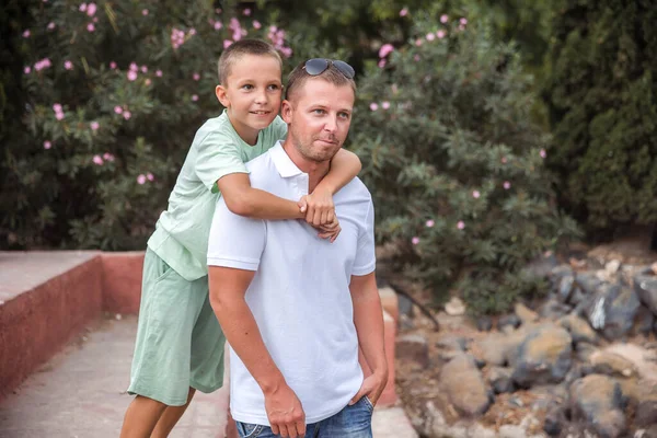Father and son walk in the city park, the concept of family rest and healthy rest of life