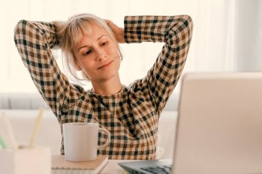 Business Woman listening educational lecture on computer, watching webinar, studying on online courses, writing notes in paper copybook, e-learning concept