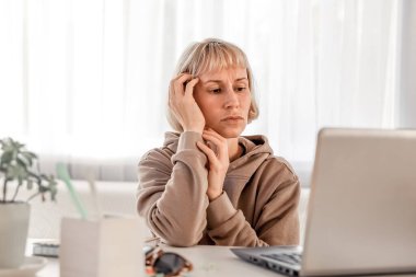 Business Woman listening educational lecture on computer, watching webinar, studying on online courses, writing notes in paper copybook, e-learning concept