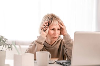 Business Woman listening educational lecture on computer, watching webinar, studying on online courses, writing notes in paper copybook, e-learning concept