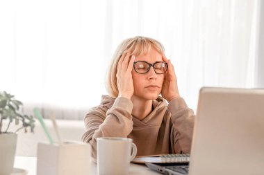 Business Woman listening educational lecture on computer, watching webinar, studying on online courses, writing notes in paper copybook, e-learning concept