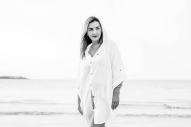 Portrait of a woman on the beach, ocean, unity with nature, healthy lifestyle. Monochrome color, Black and white conceptual shot of a business woman on vacation