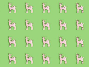 Açık yeşil arka planda kuş olan el yapımı ahşap geyiğin güzel deseni. Noel ya da Yeni Yıl dekorasyonu.