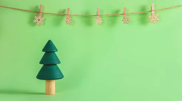 The beautiful handmade wooden fir trees on the green background with copyspace. — Stock Photo, Image