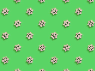 Yeşil arka planda el yapımı ahşap kar tanesinin güzel deseni.