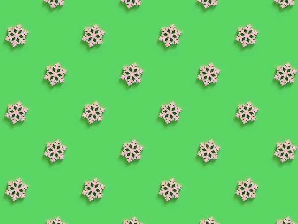 Beautiful pattern of the handmade wooden snowflake on the green background. — Stock Photo, Image