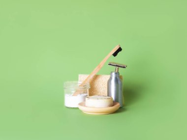 Bambu diş fırçası, çelik ustura ve yeşil arka plana karşı bir doğal sabun..