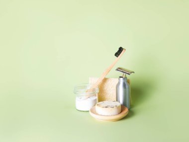 Bambu diş fırçası, çelik ustura ve yeşil arka plana karşı bir doğal sabun..