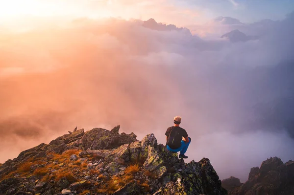 Πεζοπόρος Μαύρα Κάθεται Μόνος Στην Κορυφή Του Βράχου Υπέροχη Αυγή — Φωτογραφία Αρχείου