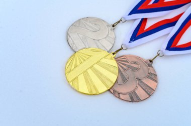 Kış sporları kupası. Altın, gümüş ve bronz madalya. Arka planda beyaz kar var. Beyaz düzenleme alanı