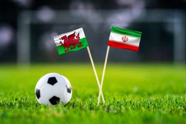 Galler İran 'a karşı, Ahmad Bin Ali, futbol maçı duvar kağıdı, el yapımı ulusal bayraklar ve yeşil çimlerde futbol topu. Arka planda futbol stadyumu var. Siyah düzenleme alanı.