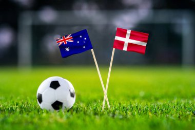 Ekim 2022: Avustralya, Danimarka, Al Janoub Stadyumu, futbol maçı duvar kağıdı, el yapımı ulusal bayraklar ve yeşil çimlerde futbol topu. Arka planda futbol stadyumu var. Siyah düzenleme alanı.