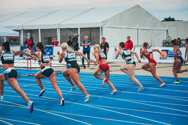 SAMORIN, SLOVAKIA, 9. JULY: Track and Field professional 100m sprint race with Hurdles. Running and Athletics photo. Sport event on blue track. Preparation for the world championship