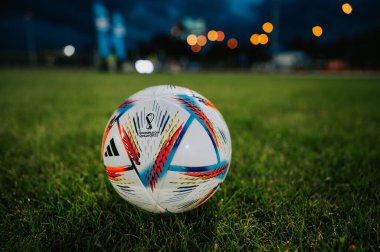QATAR, DOHA, 18 JULY, 2022: Official Adidas Fifa World Cup Football Ball Al Rihla. World Championship in Qatar 2022. Soccer Match Ball on green grass in night at Stadium. FIFA 22, black edit space.