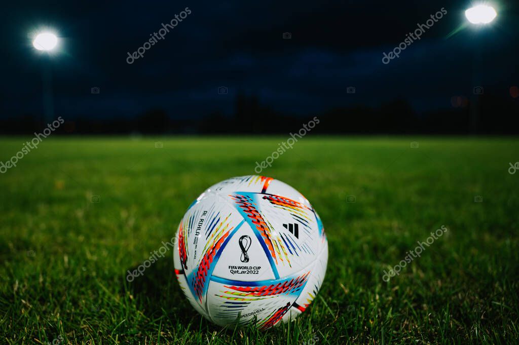QATAR, DOHA, 18 JULY, 2022: Official Adidas Fifa World Cup Football Ball Al Rihla. World Championship in Qatar 2022. Soccer Match Ball on green grass in night at Stadium. FIFA 22, black edit space.