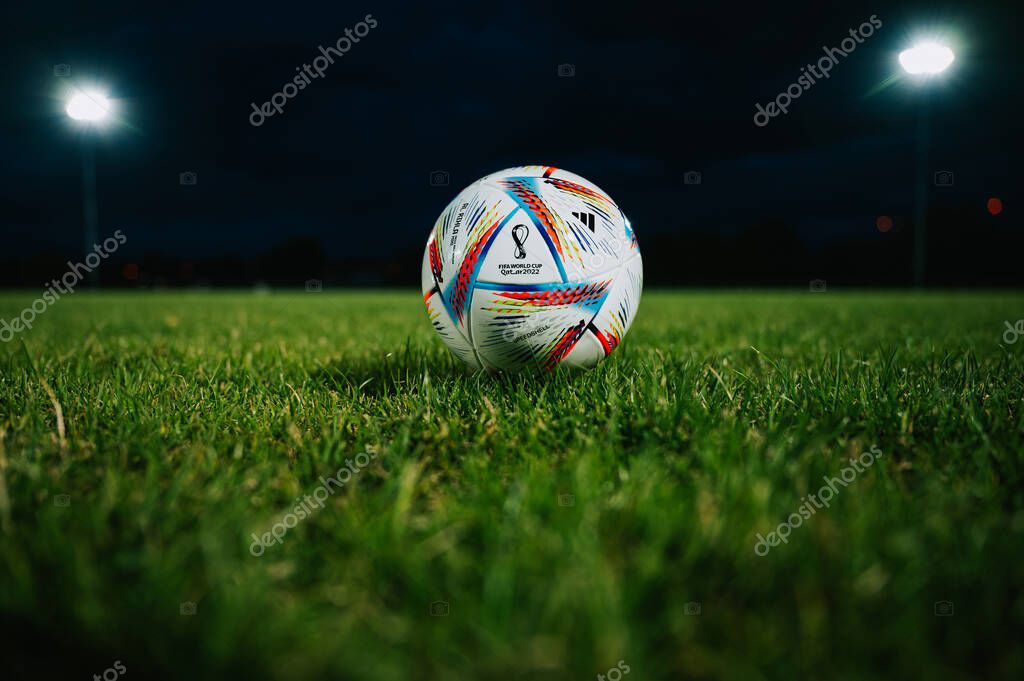 QATAR, DOHA, 18 JULY, 2022: Official Adidas Fifa World Cup Football Ball Al Rihla. World Championship in Qatar 2022. Soccer Match Ball on green grass in night at Stadium. FIFA 22, black edit space.