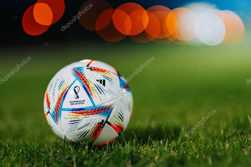 QATAR, DOHA, 18 JULY, 2022: Official Adidas Fifa World Cup Football Ball Al Rihla. World Championship in Qatar 2022. Soccer Match Ball on green grass in night at Stadium. FIFA 22, black edit space.