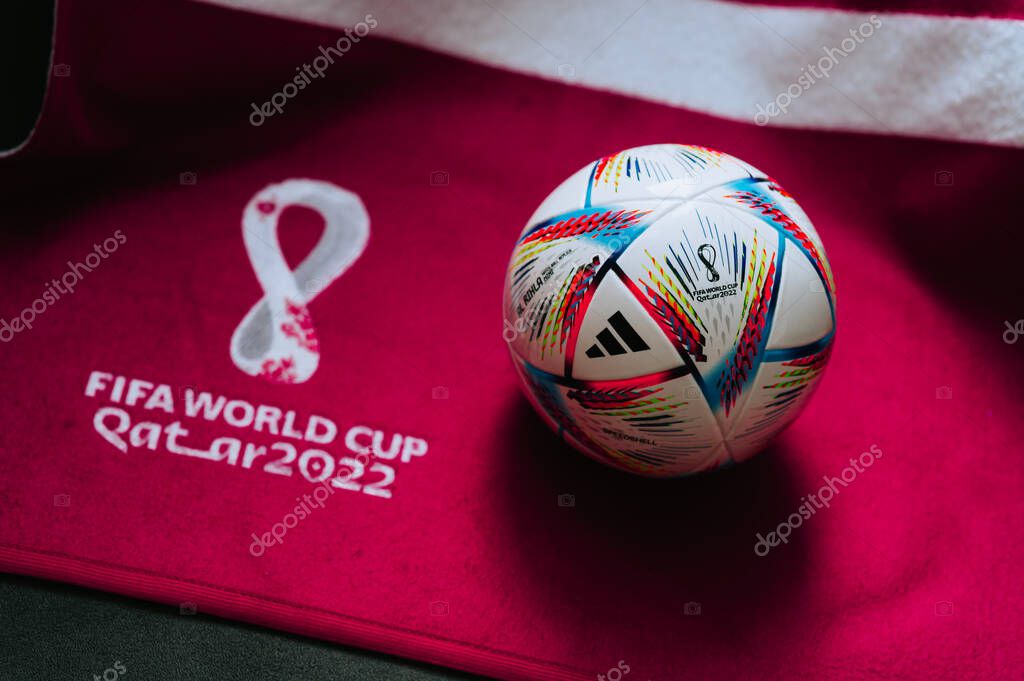 QATAR, DOHA, 18 JULY, 2022: Official Adidas World Cup Football Ball Al Rihla. And logo of FIFA World Cup in Qatar 2022 on red carpet. Soccer sport background, edit space. Qatar 22 Wallpaper.