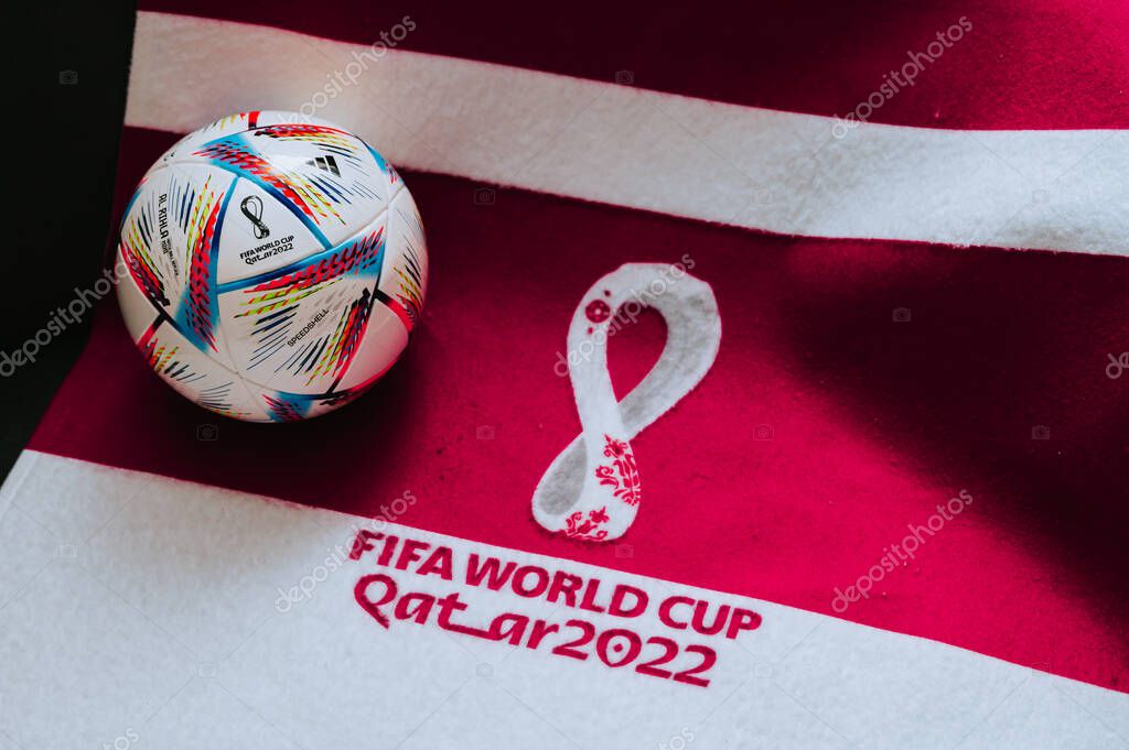 QATAR, DOHA, 18 JULY, 2022: Official Adidas World Cup Football Ball Al Rihla. And logo of FIFA World Cup in Qatar 2022 on red carpet. Soccer sport background, edit space. Qatar 22 Wallpaper.