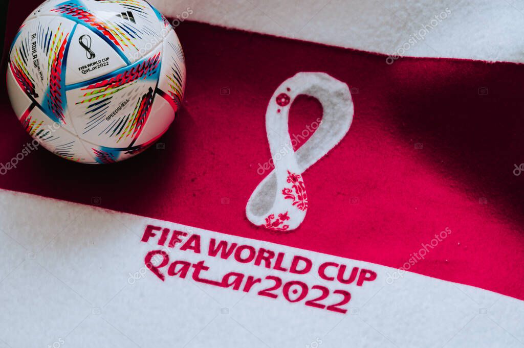 QATAR, DOHA, 18 JULY, 2022: Official Adidas World Cup Football Ball Al Rihla. And logo of FIFA World Cup in Qatar 2022 on red carpet. Soccer sport background, edit space. Qatar 22 Wallpaper.