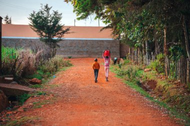 Afrika 'daki çocukların sıkı çalışması ve hayatı. Kenya 'da yolda yürüyen iki küçük çocuk. Afrika 'daki gençler için zorlu bir çocukluk.
