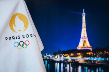 PARIS, FRANCE, AUGUST 8. 2022: Summer olympic game Paris 2024 black background. Official logo of SOG 2024 in Paris on white blanket with dark Eiffel Tower in night. Black edit space, sport event